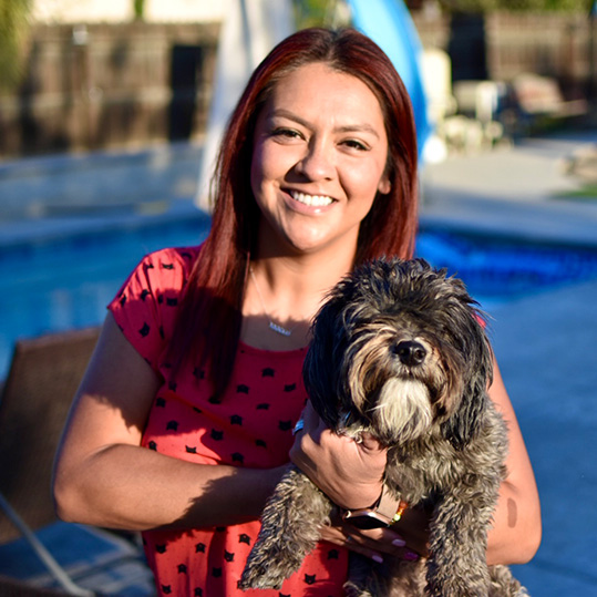 Photo of Ivy Ruiz holding her dog, Avocado.